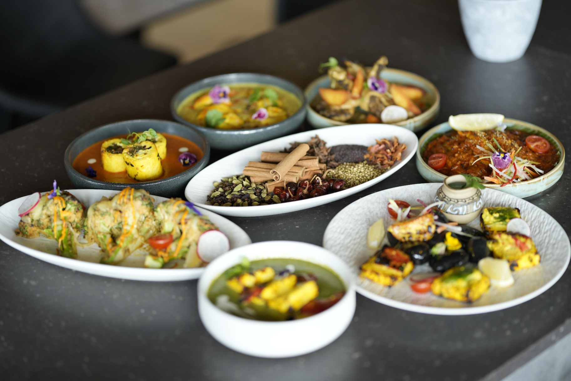 Overhead feast of Stonewater dishes with whole spices
