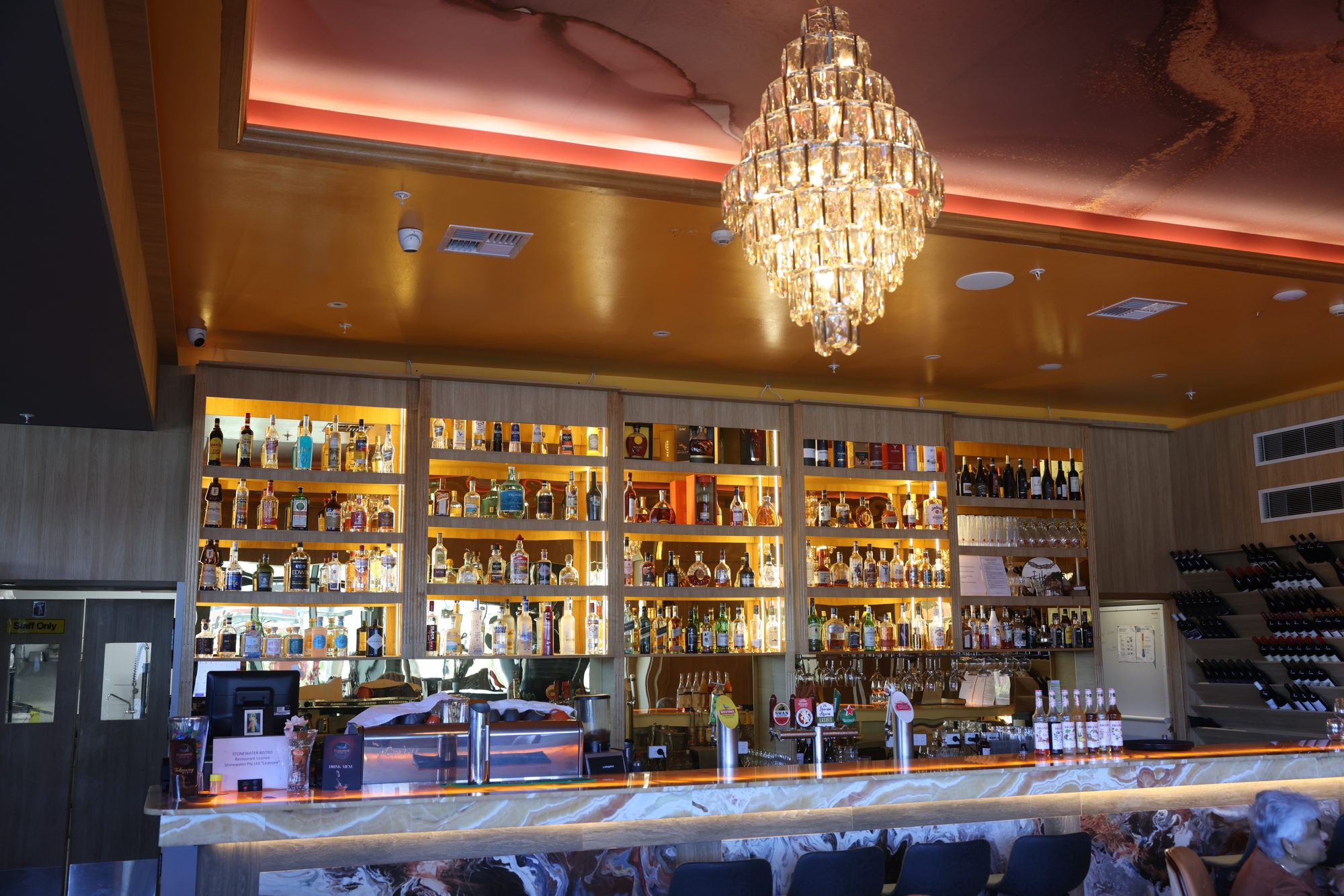 Bar and lounge with chandelier and liquor wall