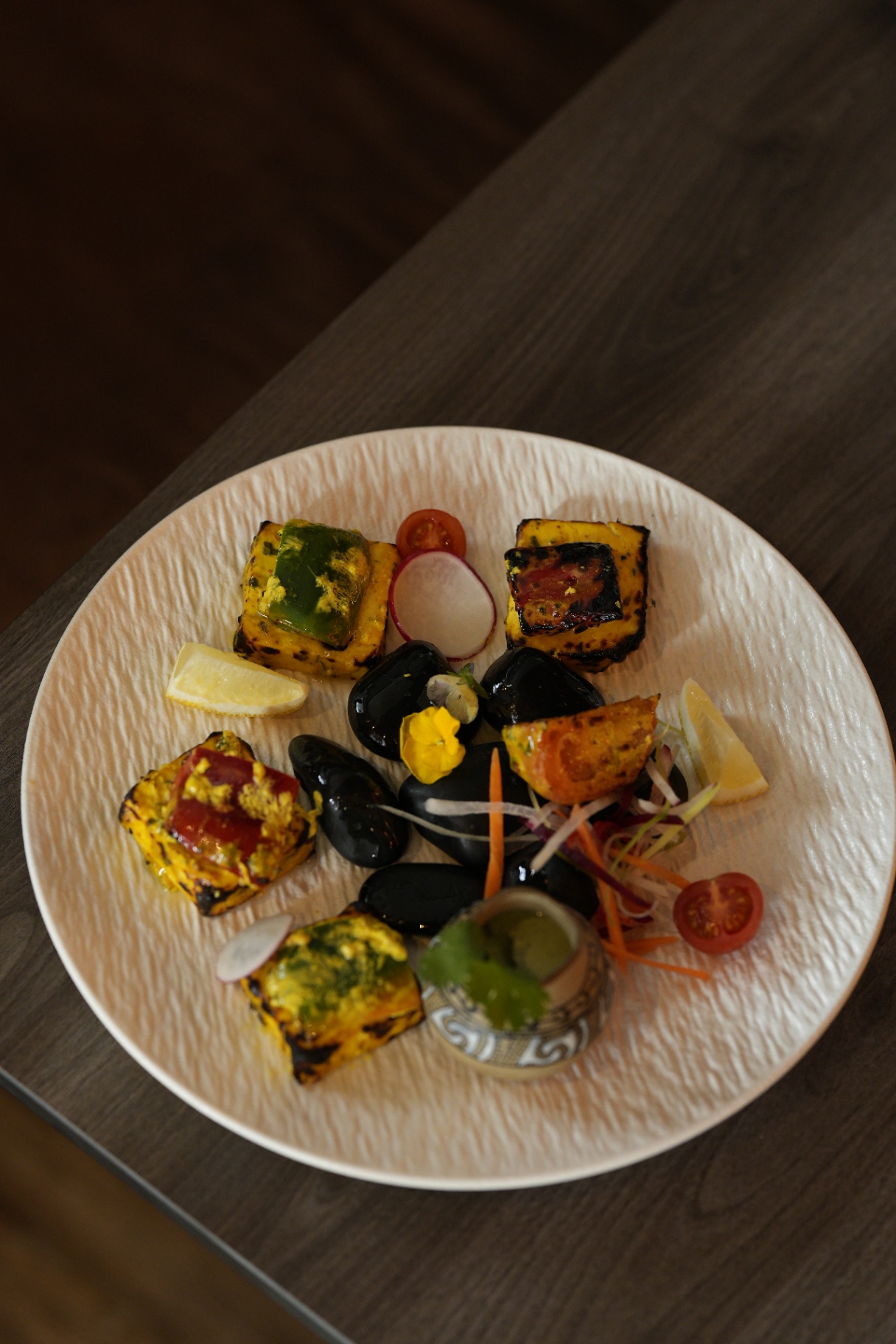 Paneer tikka with stone garnish, top-down