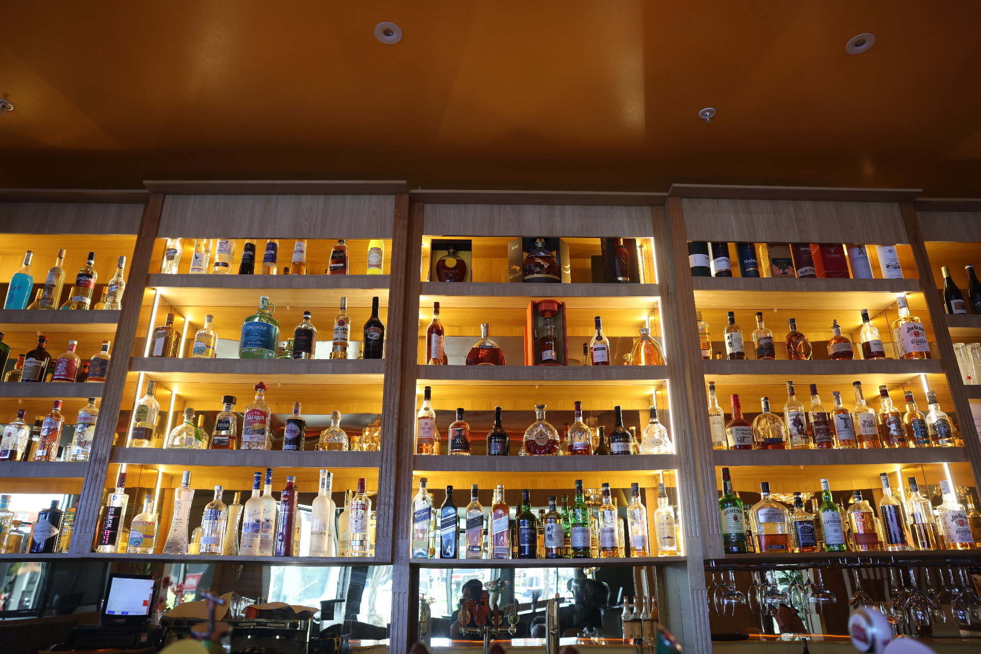 Stonewater premium liquor wall lit in warm gold